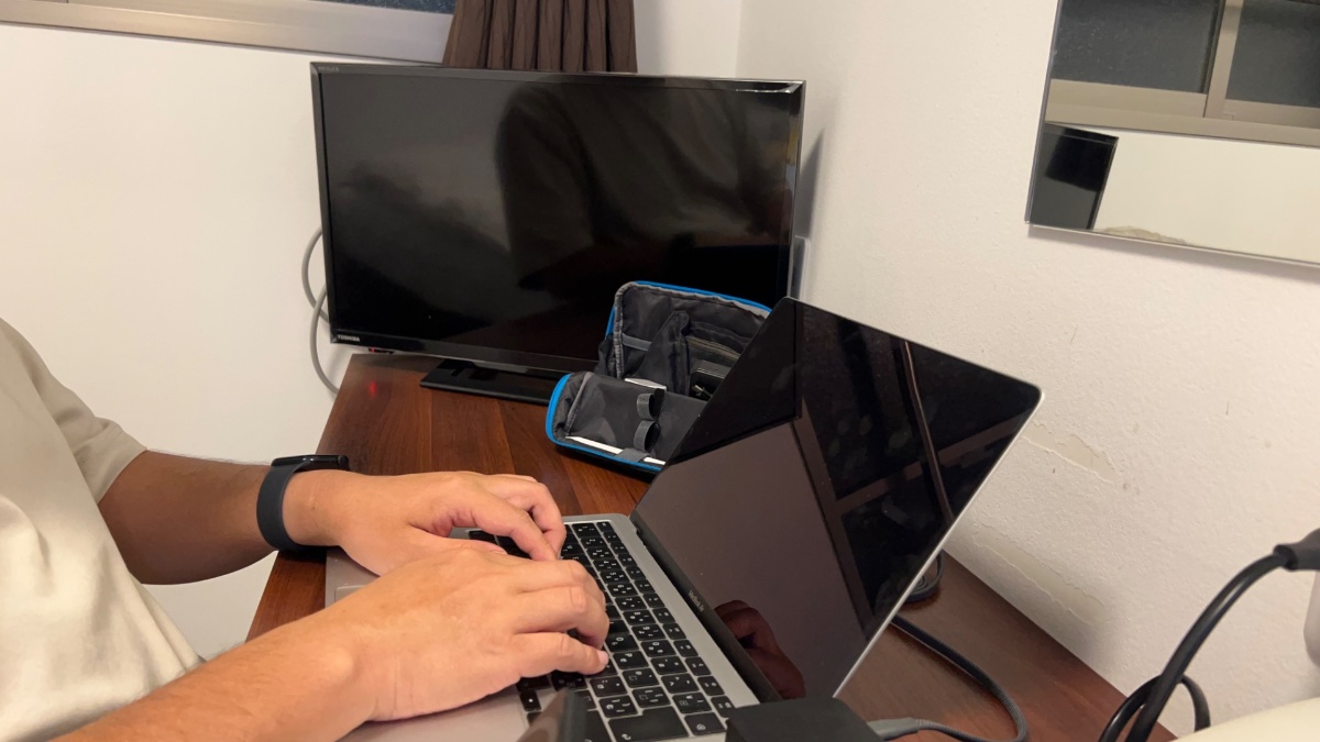 ビジネスホテルあさひのデスクでPC作業中（テレビはデスク端に設置）