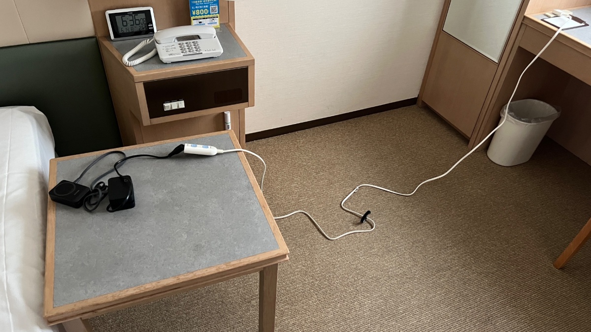小田急ステーションホテル本厚木のベッド横へ延長コードで電源を引いた様子